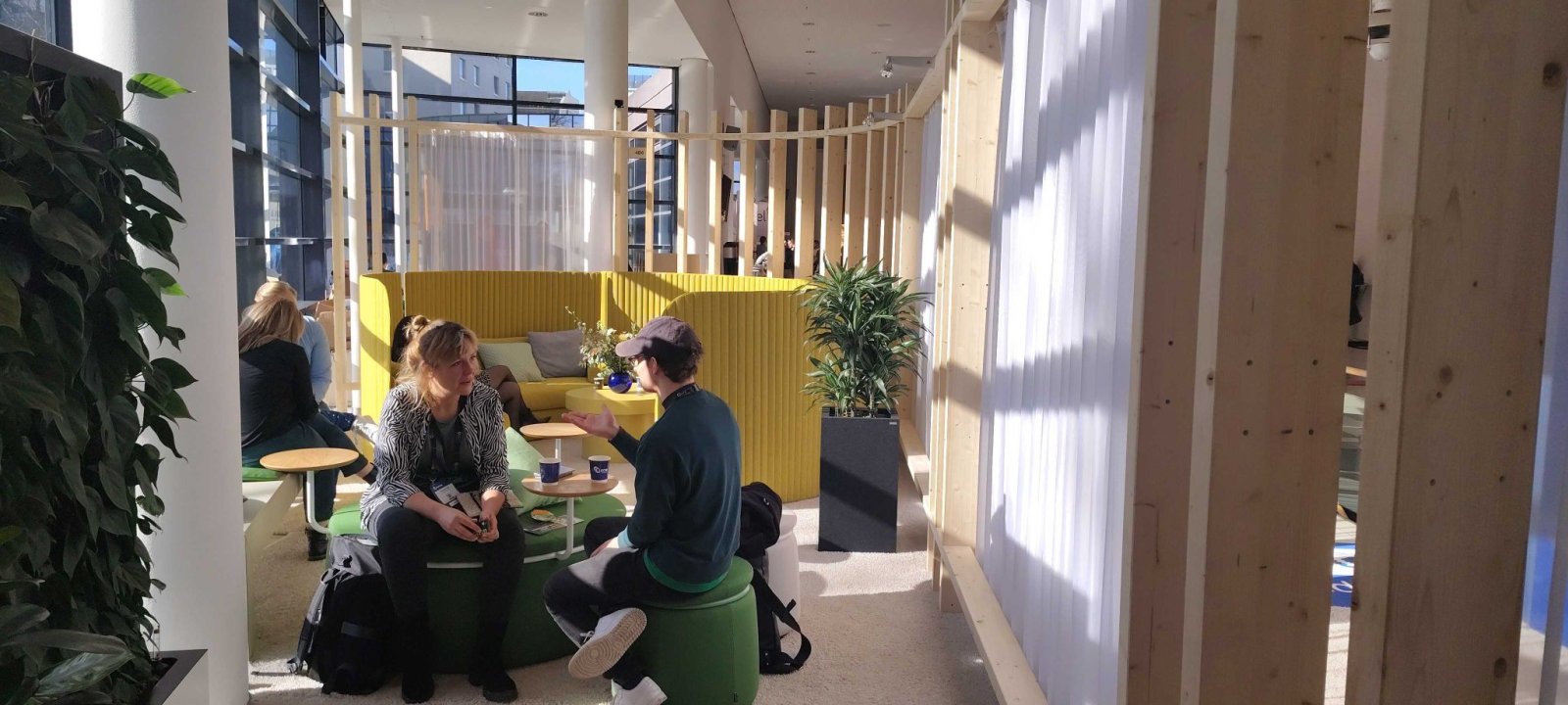 People talking in a sunny room with green and yellow furniture